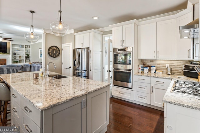 kitchen with light stone counters, dark wood-style flooring, stainless steel appliances, crown molding, and a sink