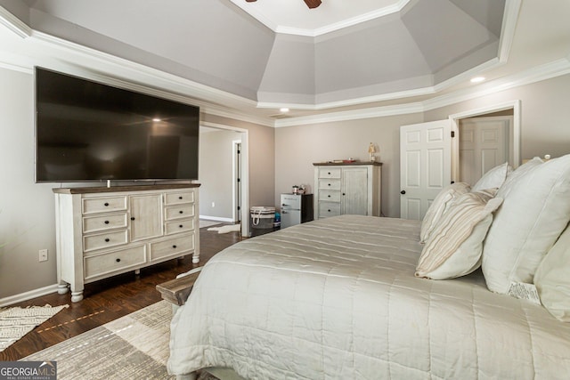 bedroom with crown molding, a raised ceiling, dark wood-type flooring, a ceiling fan, and baseboards