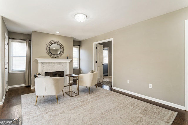 living room featuring dark wood finished floors, baseboards, and a premium fireplace