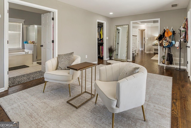 living area with baseboards, visible vents, wood finished floors, and recessed lighting