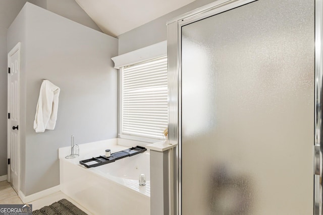 full bathroom featuring baseboards, tile patterned flooring, vaulted ceiling, a shower stall, and a bath