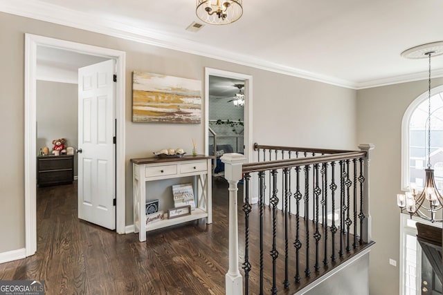 corridor with crown molding, dark wood-type flooring, visible vents, and a notable chandelier