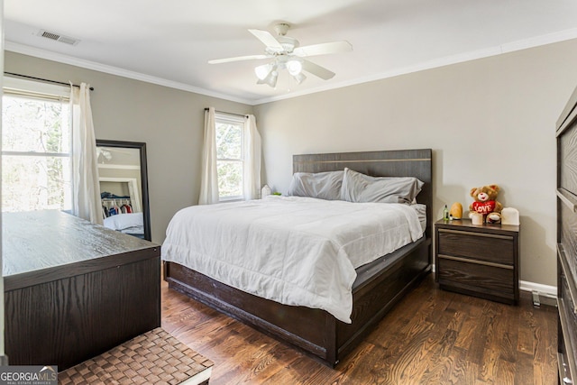 bedroom featuring ornamental molding, wood finished floors, visible vents, and a ceiling fan