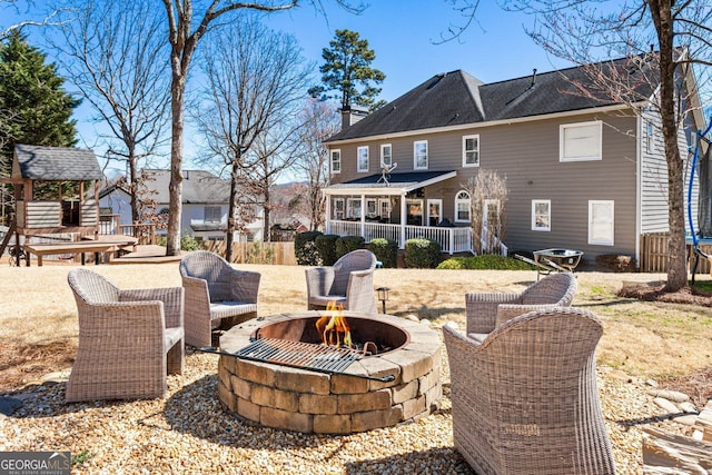 rear view of house featuring an outdoor fire pit and a chimney