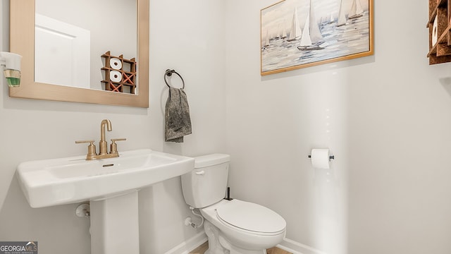 bathroom with toilet and baseboards