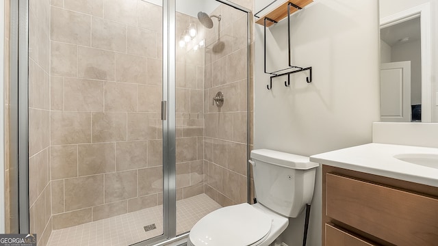 bathroom featuring toilet, a stall shower, and vanity