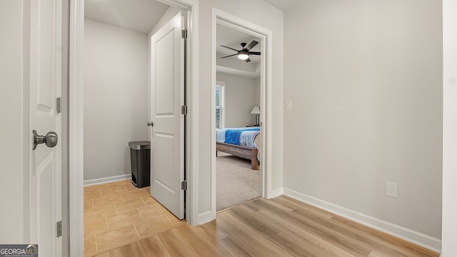 hall featuring light wood-type flooring and baseboards