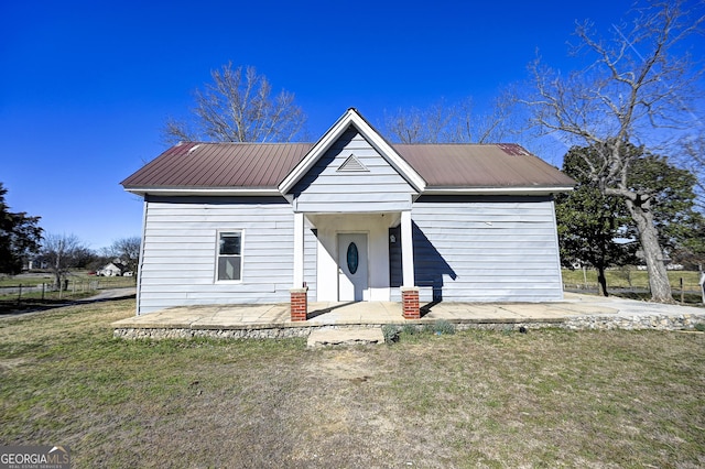 view of front of house featuring a front yard, a patio area, and metal roof