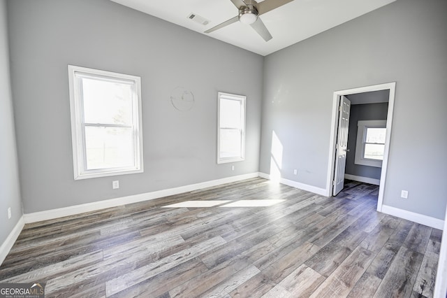 unfurnished room featuring visible vents, baseboards, wood finished floors, and a ceiling fan