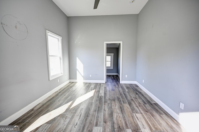 spare room featuring ceiling fan, baseboards, and wood finished floors