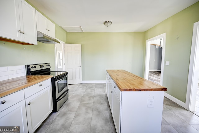 kitchen with a center island, under cabinet range hood, butcher block counters, electric range, and white cabinetry