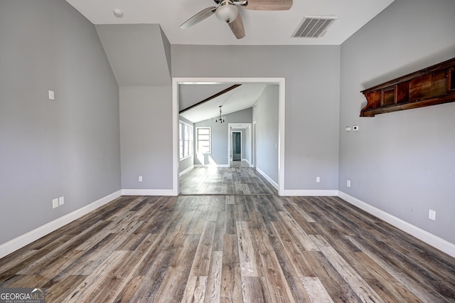 unfurnished room with visible vents, baseboards, wood finished floors, and vaulted ceiling