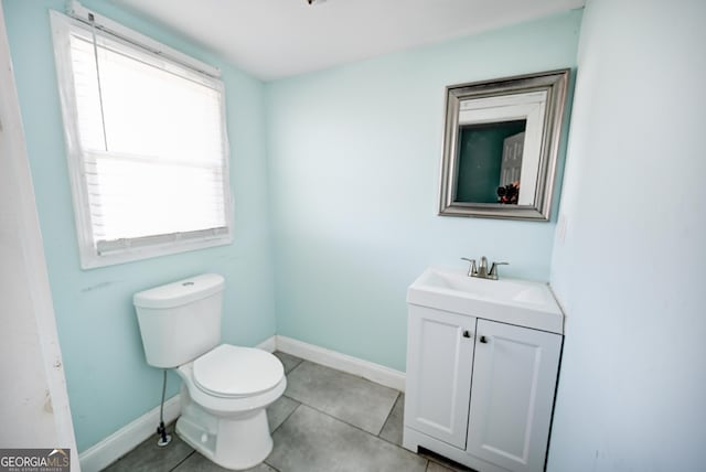 bathroom featuring tile patterned flooring, toilet, vanity, and baseboards