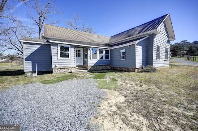 ranch-style house with entry steps, metal roof, and driveway