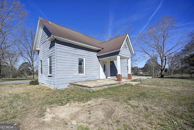 exterior space with a lawn and metal roof