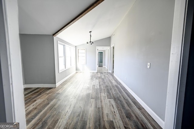 interior space with dark wood finished floors, vaulted ceiling with beams, and baseboards