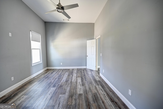 unfurnished room featuring dark wood finished floors, visible vents, a ceiling fan, and baseboards