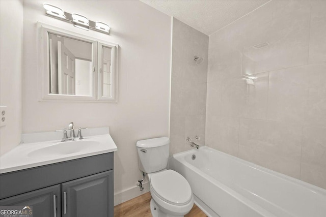 full bath featuring toilet, wood finished floors, bathing tub / shower combination, vanity, and baseboards