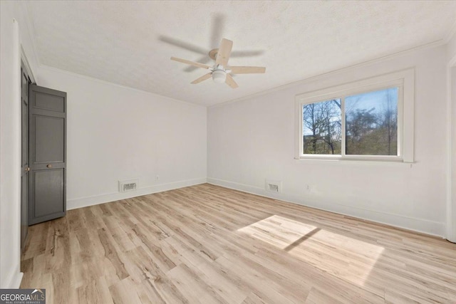 interior space featuring ornamental molding, visible vents, and light wood-style floors