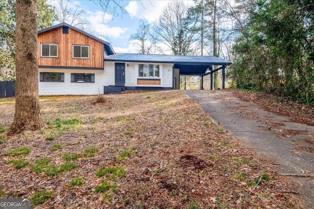 split level home with driveway, metal roof, and an attached carport