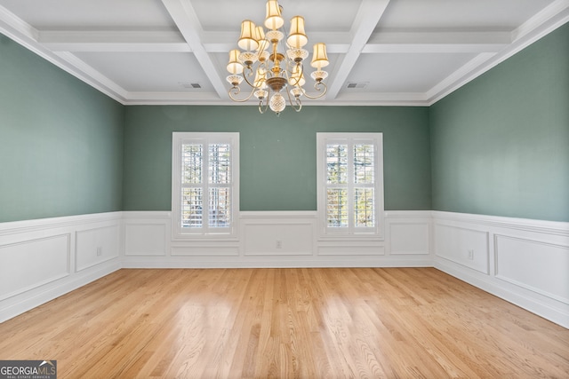 unfurnished dining area featuring plenty of natural light, visible vents, beam ceiling, and wood finished floors