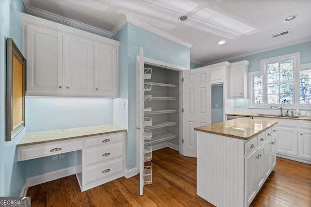 kitchen with crown molding, wood finished floors, visible vents, and white cabinetry