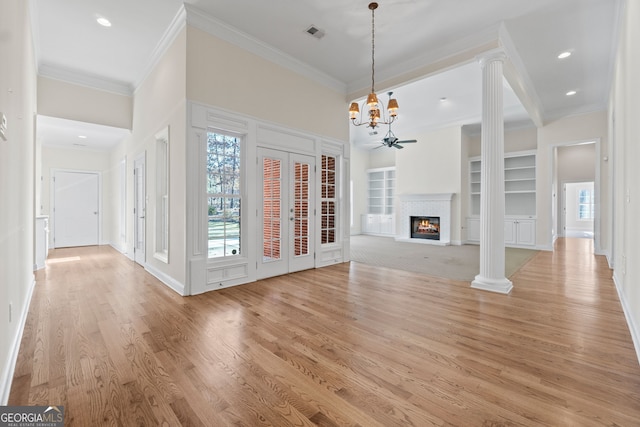 unfurnished living room with a fireplace, decorative columns, light wood finished floors, visible vents, and ceiling fan