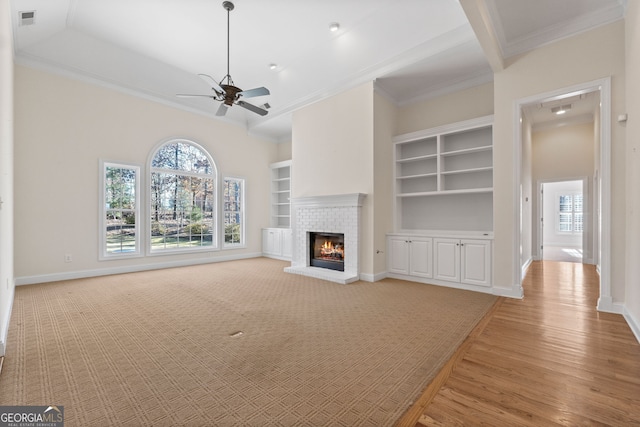 unfurnished living room with ornamental molding, visible vents, a fireplace, and baseboards