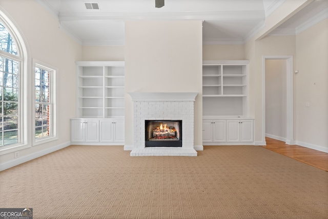 unfurnished living room with crown molding, visible vents, a fireplace, and baseboards