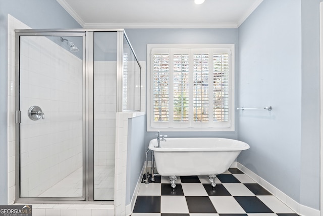 bathroom with crown molding, a shower stall, a freestanding tub, baseboards, and tile patterned floors