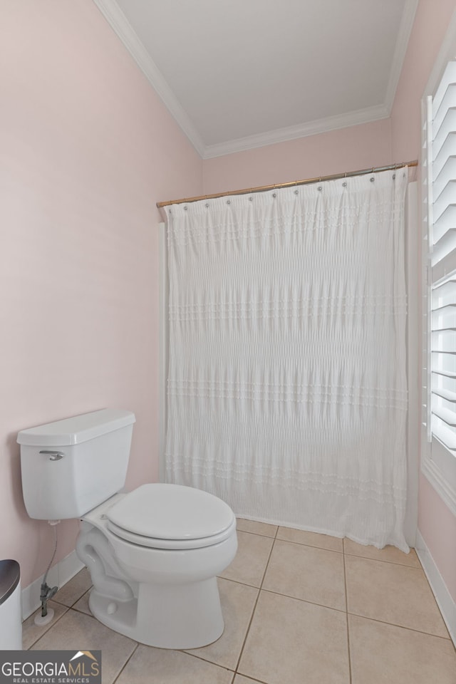 bathroom with toilet, baseboards, crown molding, and tile patterned floors