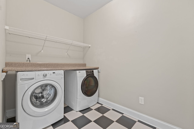 laundry area featuring baseboards, laundry area, washing machine and clothes dryer, and tile patterned floors