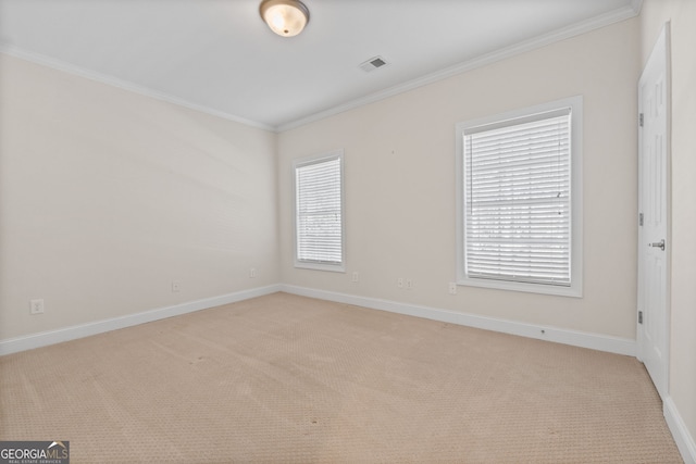 empty room featuring baseboards, visible vents, light colored carpet, crown molding, and a wealth of natural light