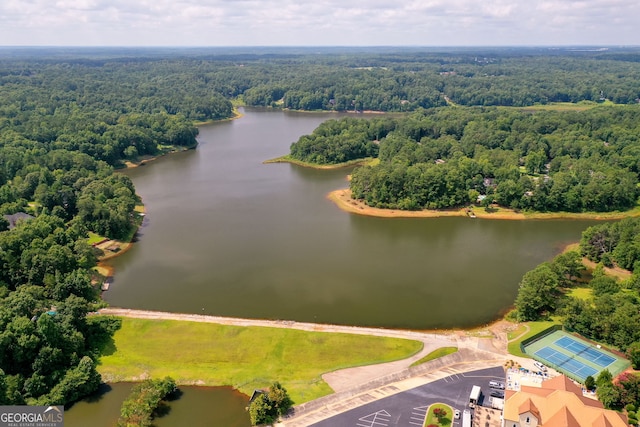 birds eye view of property with a water view and a wooded view