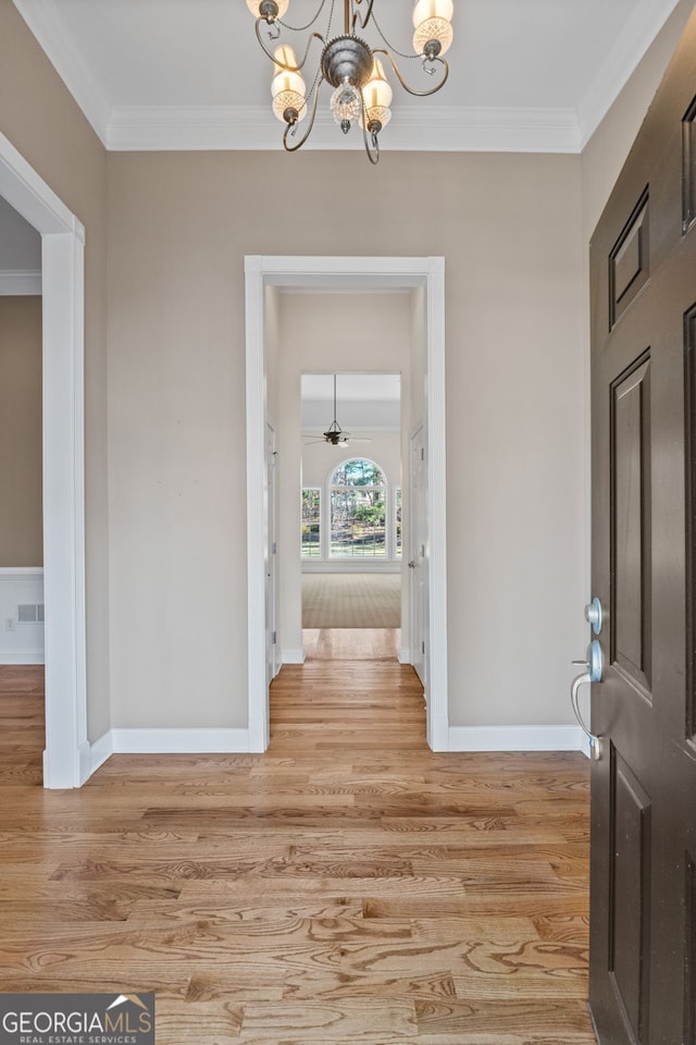 foyer with light wood-style flooring and ornamental molding