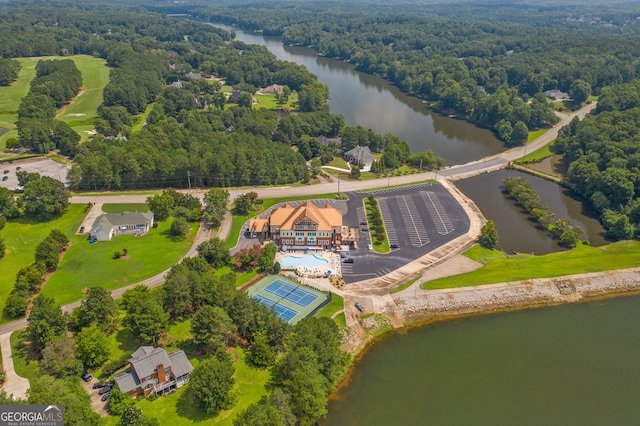 birds eye view of property featuring a water view and a wooded view