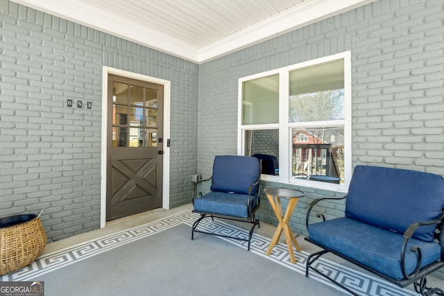 entrance to property with a patio area and brick siding