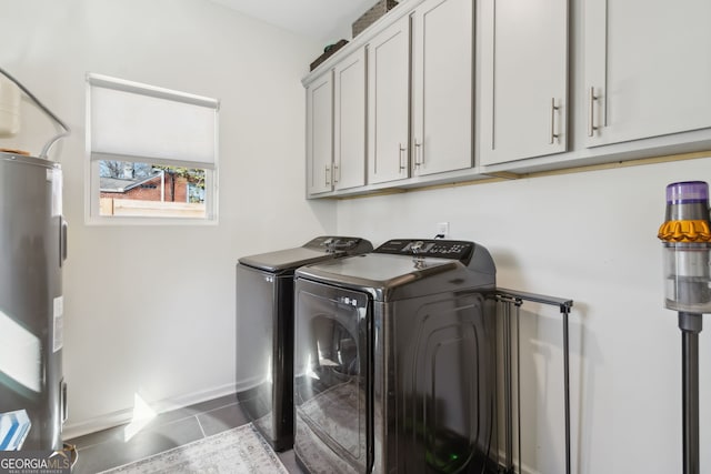 laundry room with cabinet space, baseboards, tile patterned flooring, washer and dryer, and water heater