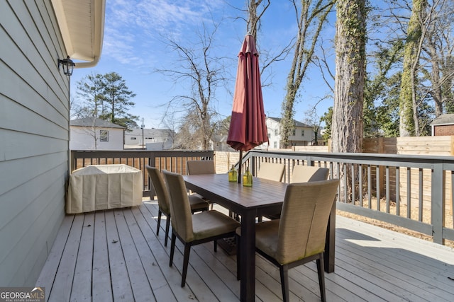 deck featuring outdoor dining area and fence