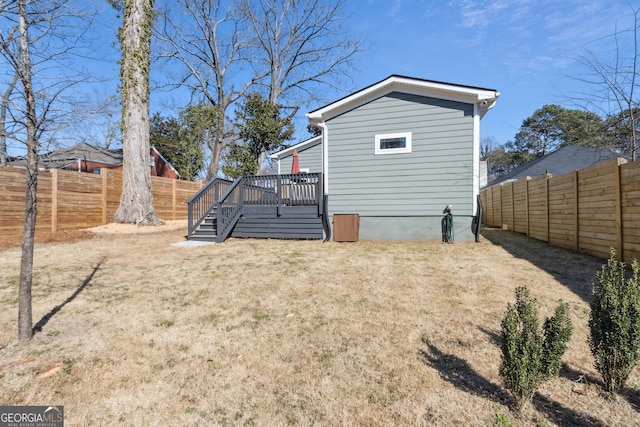 exterior space featuring a fenced backyard, a deck, and a lawn