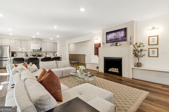 living area featuring a fireplace, wood finished floors, and recessed lighting