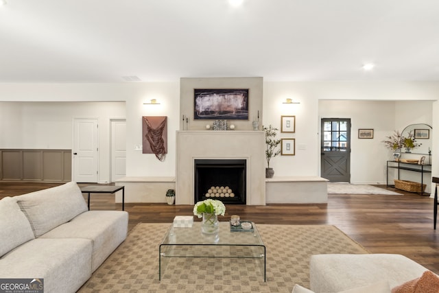 living room with a fireplace, wood finished floors, visible vents, and baseboards