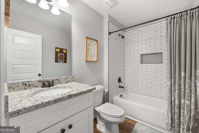 bathroom featuring visible vents, toilet, shower / bath combo with shower curtain, vanity, and wood finished floors