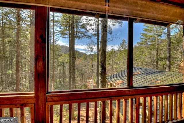 unfurnished sunroom with a forest view