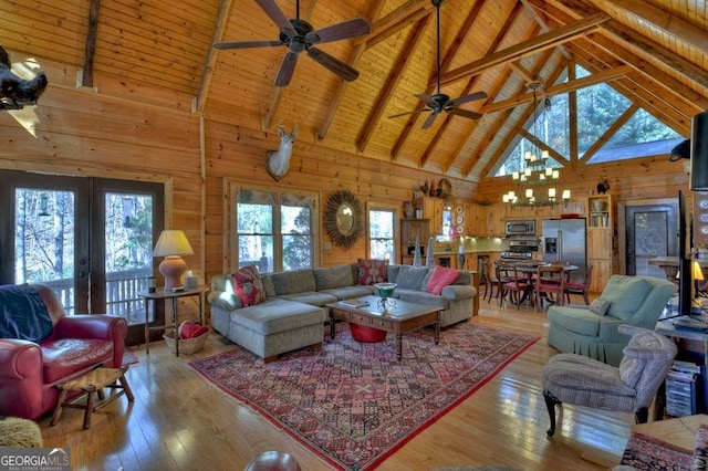 living room with wooden walls, a ceiling fan, lofted ceiling with beams, wood ceiling, and hardwood / wood-style floors