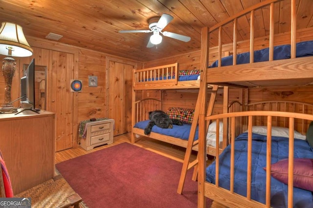 bedroom featuring wood walls, wood finished floors, and wood ceiling