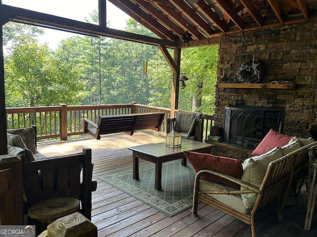 wooden terrace with an outdoor living space with a fireplace