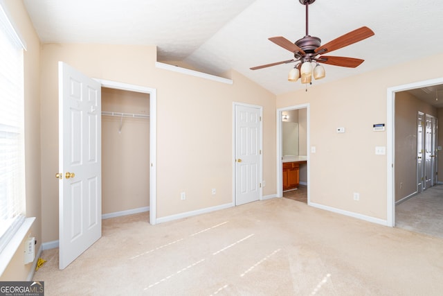 unfurnished bedroom featuring attic access, baseboards, connected bathroom, lofted ceiling, and carpet floors