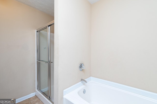 full bath with a shower with shower door, a textured ceiling, a tub, baseboards, and tile patterned floors