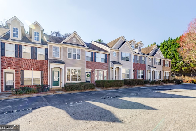 townhome / multi-family property with a residential view and brick siding